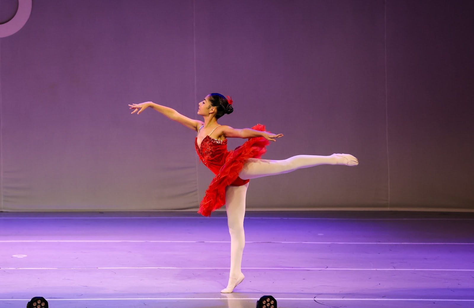 Bailarina da EIDD em arabesque com figurino vermelho