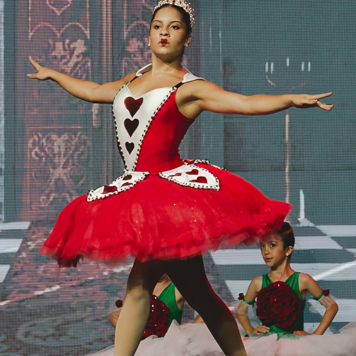 Bailarina como Rainha de Copas em tutu vermelho no espetáculo 2024