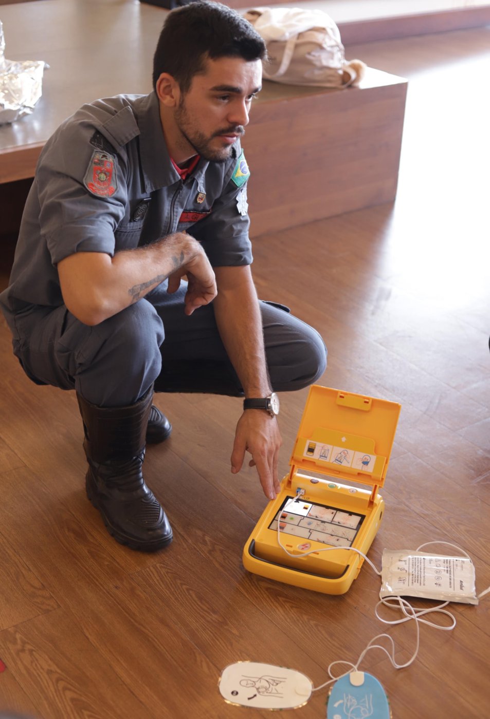 Bombeiro apresentando o desfibrilador externo automático (DEA) à equipe da EIDD