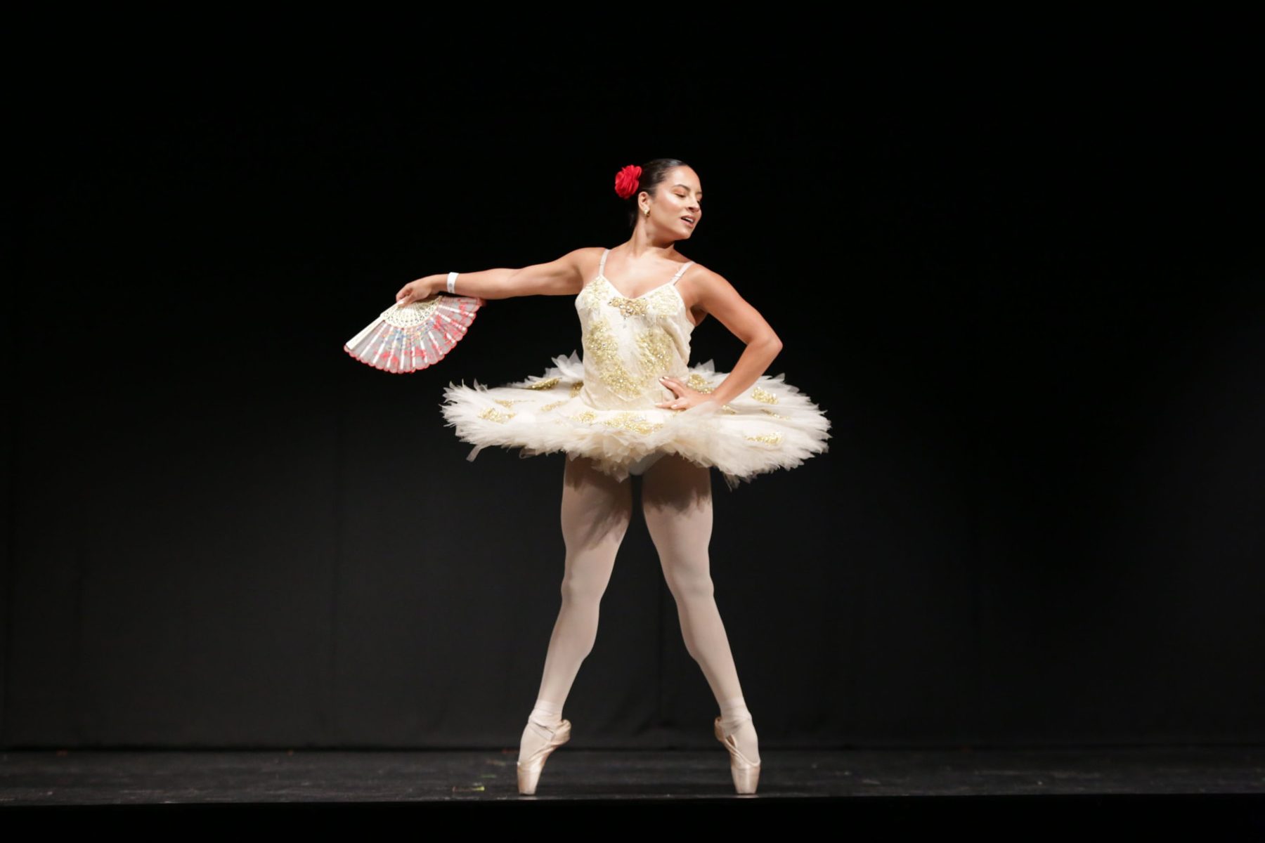 Bailarina da EIDD em variação clássica com leque, nas pontas