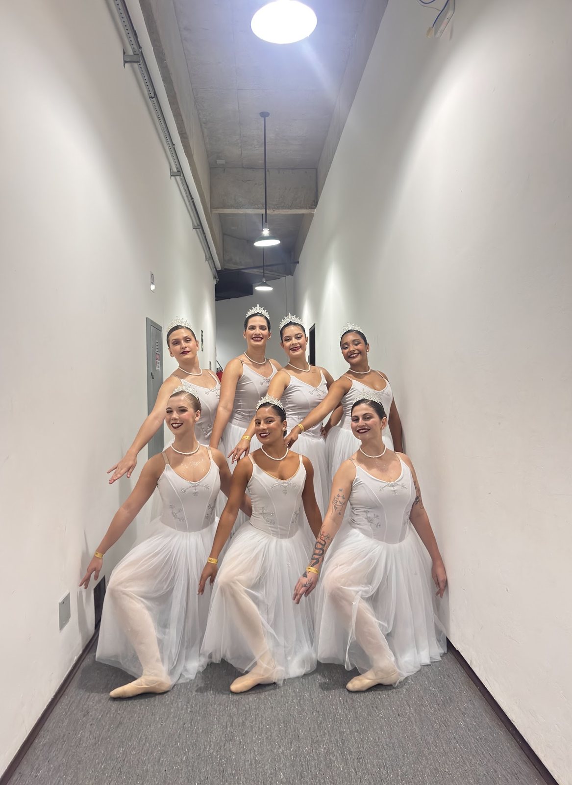 Grupo de bailarinas da EIDD com tutus brancos nos bastidores