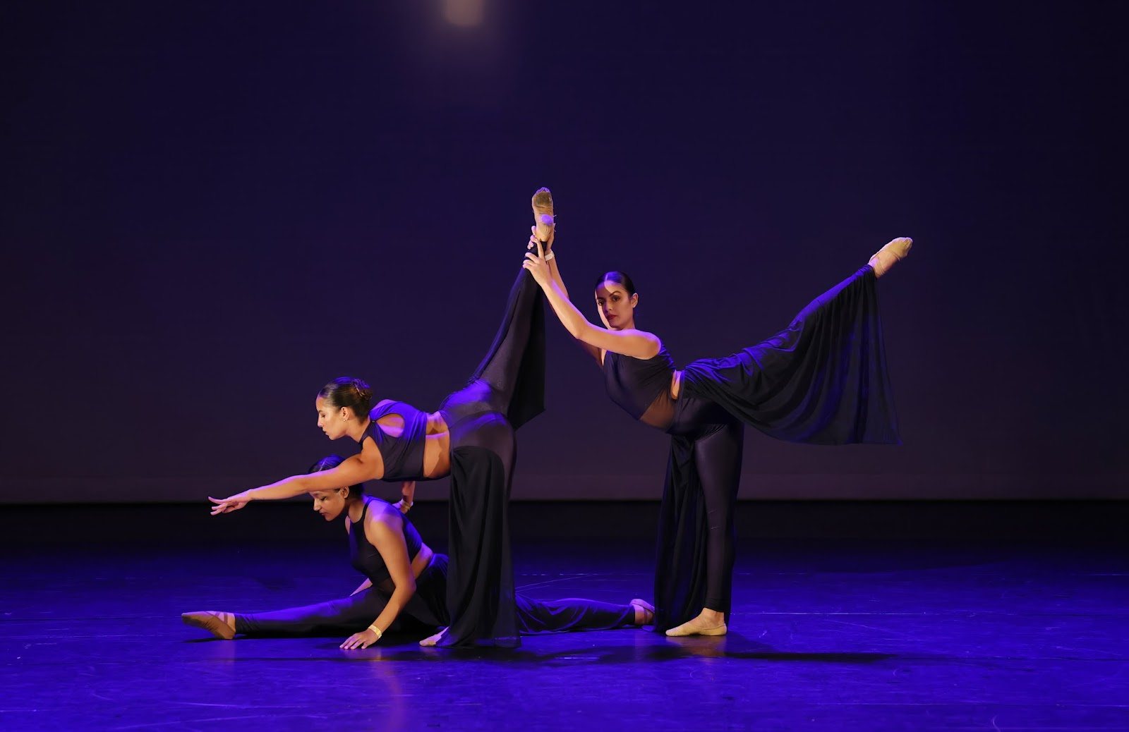 Coreografia em grupo da EIDD no palco sob luz azul